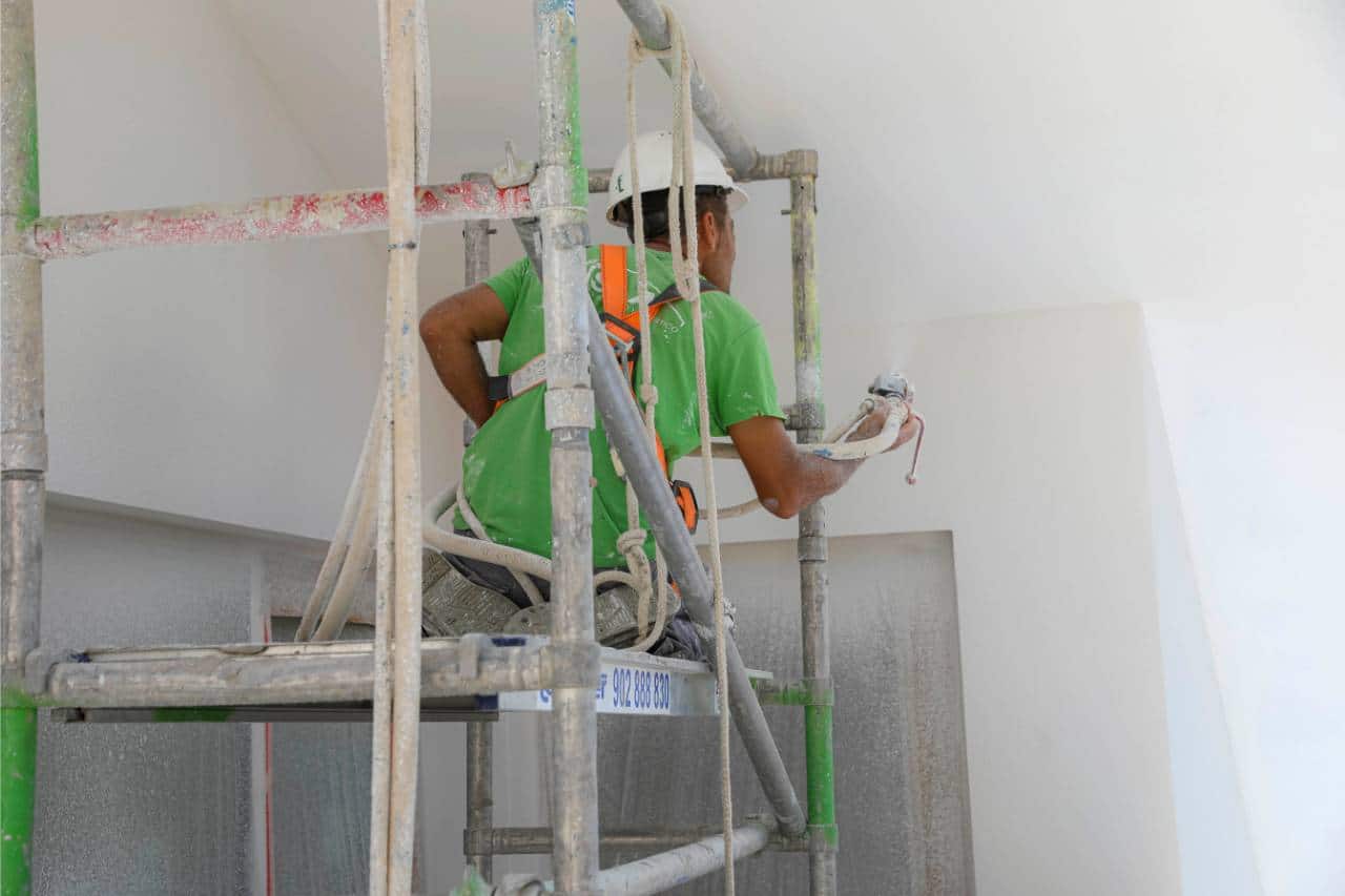 Operario aplicando pintura SATE